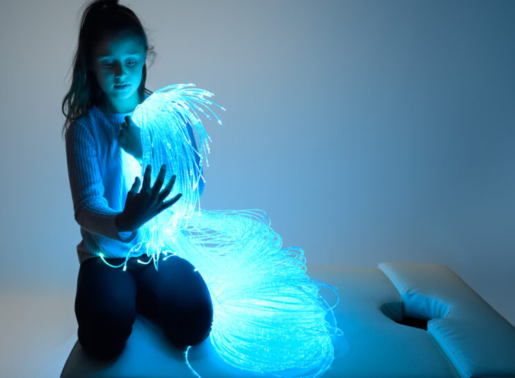 Playlearn product, young girl intrigued by glowing fiber optic product